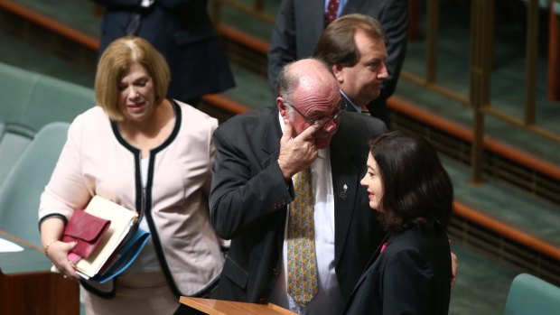 Warren Entsch wipes a tear away with Labor MP Terri Butler.