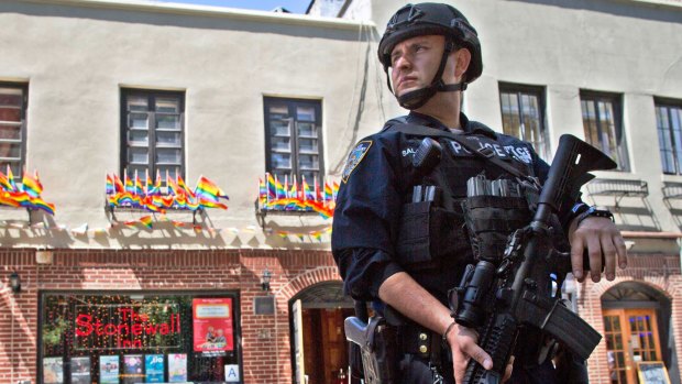 An armed police officer stands guard outside a pub in New York after a gunman attacked at a gay nightclub in Orlando, Florida.