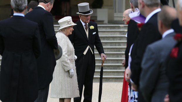 The Queen and Prince Philip greet guests on the grounds of Buckingham Palace on Thursday.