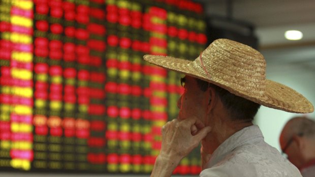 A Chinese investor studies an electric board showing sharemarket information at a brokerage house in Haikou. China's surprise decision to allow its currency to fall hit the shares of airlines and importers, but boosted exporters, as investors bet a weaker yuan would help their competitiveness. 