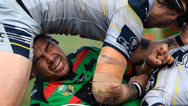 Grind: Cody Walker of the Rabbitohs is tackled by  Ethan Lowe  and Justin O'Neil of the Cowboys in Cairns on Sunday.