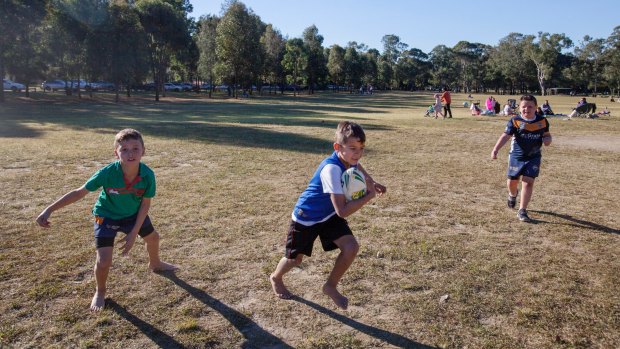 The Toomey family enjoying a game of rugby on the very dry grass in Parramatta Park.