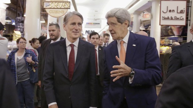US Secretary of State John Kerry, right, and British Foreign Secretary Philip Hammond walk through the Quincy Market food court after visiting the Wind Technology Testing Centre.