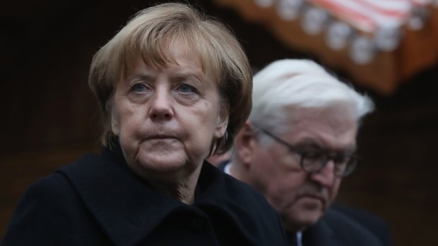 German Chancellor Angela Merkel and Foreign Minister Frank-Walter Steinmeier lay flowers at the Berlin Christmas market where 12 people died after a truck ploughed onto the crowd.