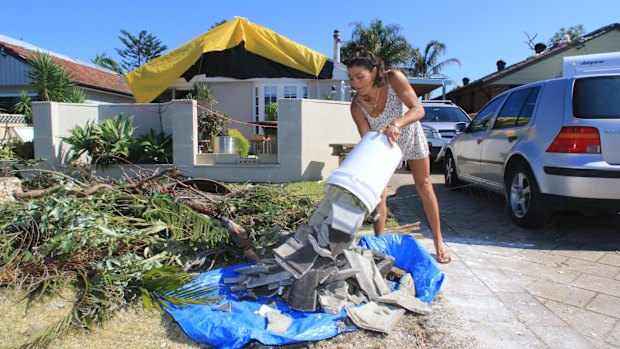 Betty Howarth dumps broken roof tiles outside her Tasman Street home in Kurnell.