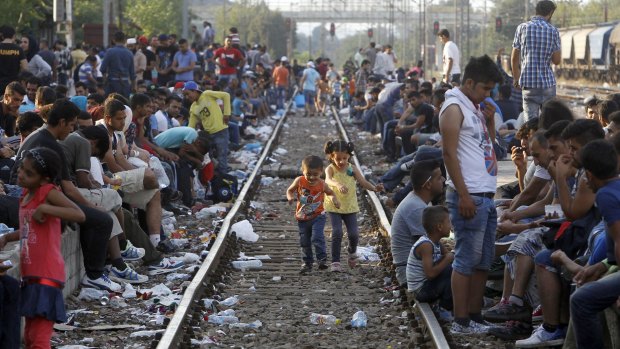 Children play on a train track as migrants wait for a train heading toward Serbia, at the railway station in the southern Macedonian town of Gevgelija in August 2015.