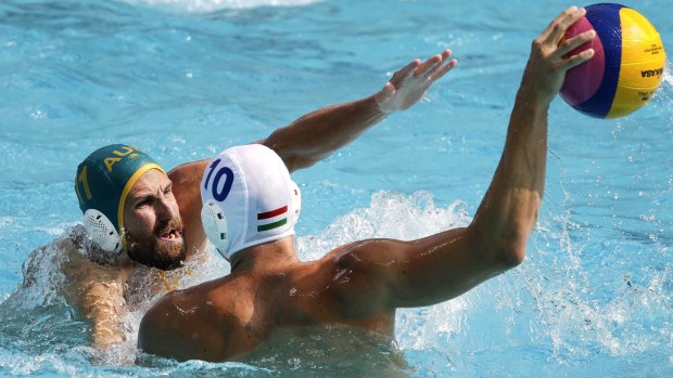 Hungary's Denes Varga takes a shot as Australia's Rhys Howden defends during their men's water polo preliminary round match on Monday.