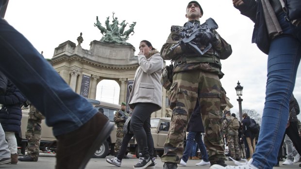 A French foreign legionnaire patrols outside the Grand Palais museum near the Champs-Élysées  in Paris.