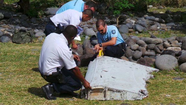 French police inspect the flaperon, now confirmed to be from MH370, on Reunion Island.