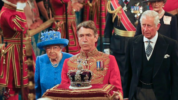 Queen Elizabeth II and Prince Charles, right, walk through the Royal Gallery in the Houses of Parliament on Wednesday.