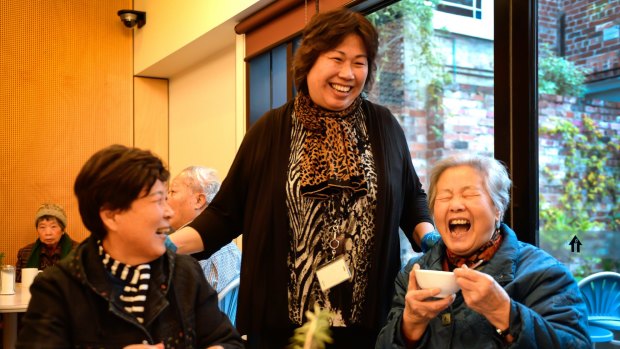 Liu Mei Ying and Wang He having a giggle at breakfast with Helen Teodor (centre)  at St Mary's House of Welcome in Fitzroy. 