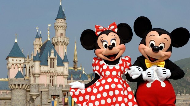 Mickey Mouse and Minnie Mouse in front of the Sleeping Beauty Castle in Hong Kong's Disneyland.