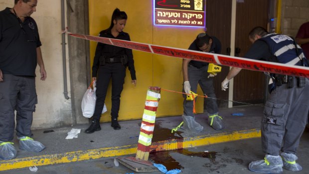 Israeli police investigates the scene of an stabbing attack in Tel Aviv on Thursday. A Palestinian man fatally stabbed two Israeli men in a Tel Aviv office building before being apprehended, police said. 