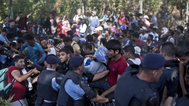 Migrants push through a police line in the eastern Croatian town of Tovarnik, with people trampling and falling on each other amid the chaos.  