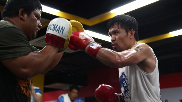 Workout: Manny Pacquiao works the pads with Buboy Fernandez at the Elorde boxing Gym in Manila on Thursday.