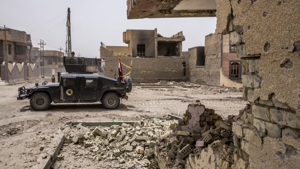 Iraqi counterterrorism forces move through the heavily damaged Shuhada neighborhood in Fallujah.