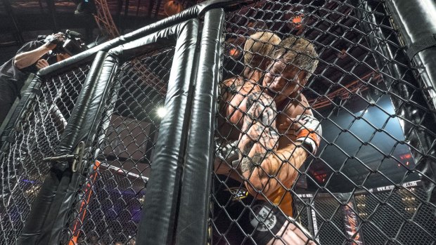 Ryan Barry, left, battles Troy Resic at Victoria's first legal MMA cage fight last night.