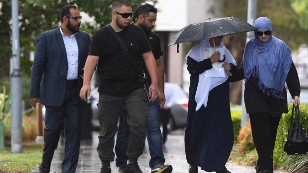 Maha Al-Shennag (with umbrella), who allegedly drove into Banksia Road Public School killing two students, arrives at Bankstown Local Court in Sydney with a group of supporters on Wednesday.