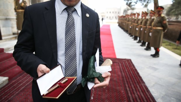 A staff member of the Presidential Palace holds the pen that Malcolm Turnbull presented to the President of Afghanistan, Ashraf Ghani during their meeting.