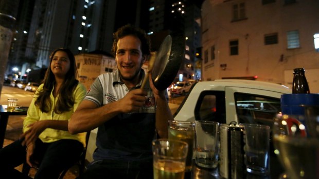 A man hits pans at a Sao Paulo bar in protest against the speech of Brazilian President Dilma Rousseff, broadcast on television.