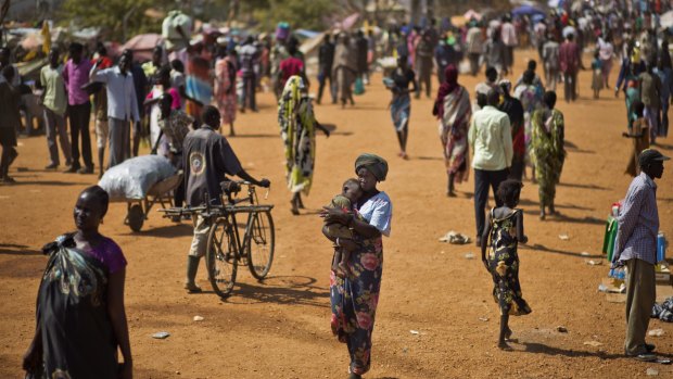 Displaced people walk in a UN compound home to thousands of people displaced by fighting, in Juba, South Sudan in 2013. 