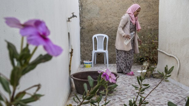 Activist Meherzia Belabed watering her flowers at home in Tunis.