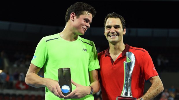 Milos Raonic and Roger Federer with their trophies after the Brisbane International final.