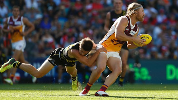 Richmond's Liam Baker tackles the Lions' Daniel Rich.