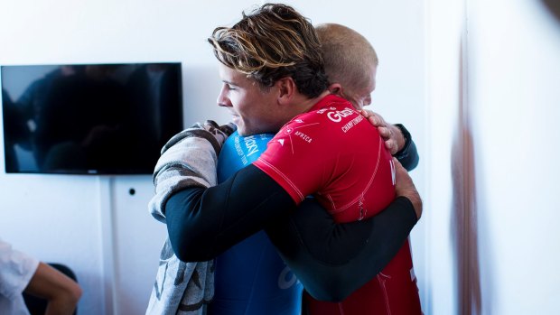 Ordeal over: Julian Wilson hugs Mick Fanning from the safety of shore.