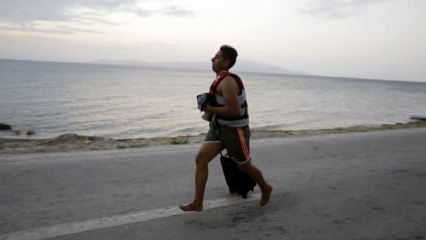 A Syrian migrant runs to meet compatriots who have just arrived on the Greek island of Lesbos from Turkey.