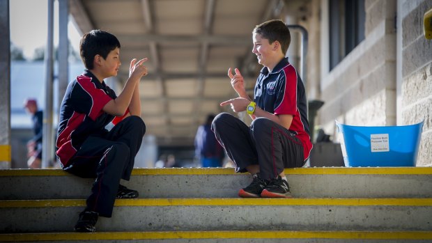 Amaroo School student Ross Kelly (right), who learnt sign language to talk with deaf friend Isam Gurung.