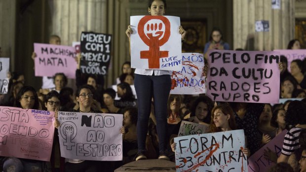 Demonstrators protest the gang rape of a 16-year-old girl in Rio. The signs  read in Portuguese "Always fight", "No to rape", "It was 33 against all (women)" and "For the end of rape culture". 