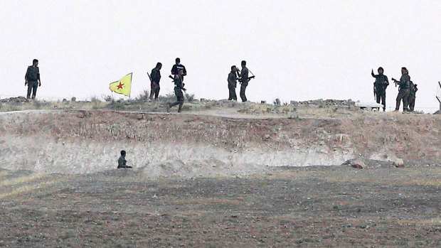 Kurdish People's Protection Units (YPG) fighters take position in the northern Syrian town of Tel Abyad on Monday.