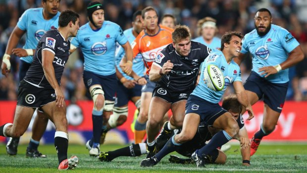 Nick Phipps of the Waratahs gets a pass away against the Sharks on Saturday night. 