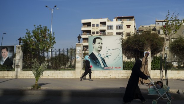 Images of president Bashar Assad dominate a fence in central Damascus.