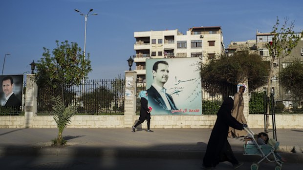 Images of president Bashar Assad dominate a fence in central Damascus.