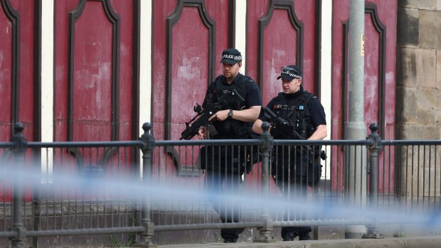 Armed police patrol the streets of Manchester the morning after the bombing.