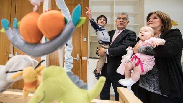 John Ajaka holds his grandson John Urbano, 2, and Speaker Shelley Hancock holds 7 month old Audrey Richards, the daughter of MP Melanie Gibbons in the new parents room.