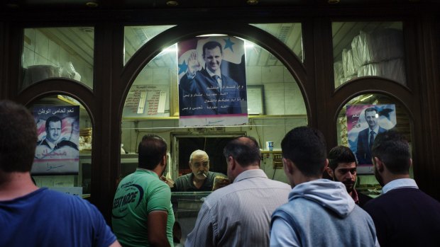 An image of Syrian president Bashar Assad hangs in a business in old city of Damascus. 