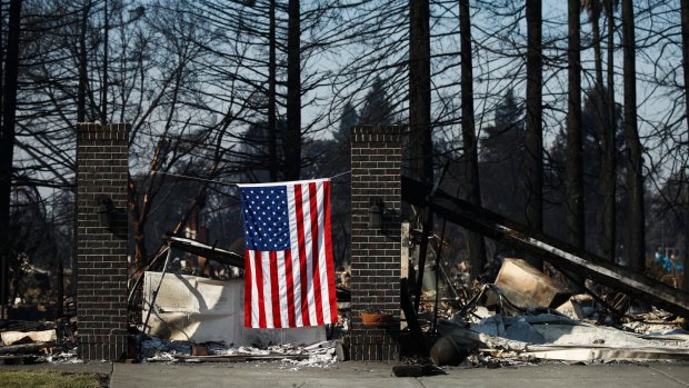 An American flag hangs on a burnt home in Santa Rosa on Sunday.
