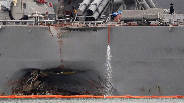 The damaged port aft hull of the USS John S. McCain, is visible while docked at Singapore's Changi naval base on Tuesday.