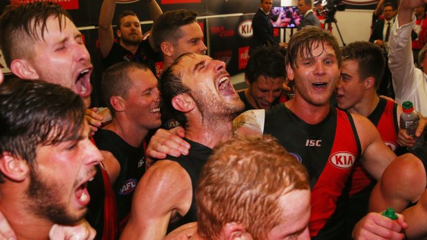 See the Bombers fly up: Jobe Watson and Michael Hurley sing the club song.