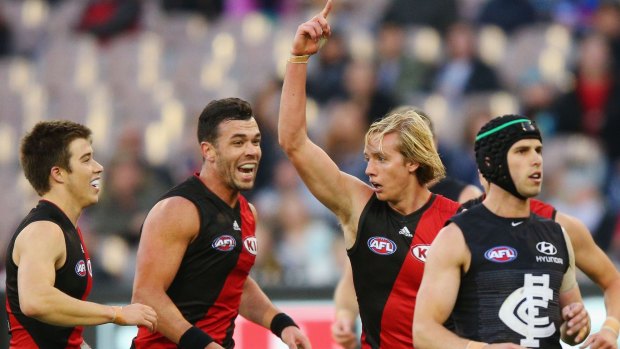 One for me: Darcy Parish of the Bombers celebrates a goal with Zach Merrett (left) and Ryan Crowley.
