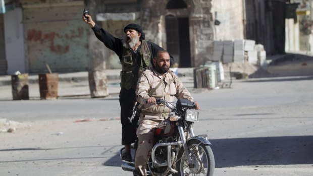 Members of al-Qaeda's Nusra Front ride a motorbike in Ariha, Syria.