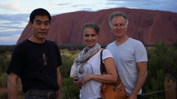 Zhou Xiaoping, Diamond Rozakeas and Brian James take in the beauty of Uluru.

