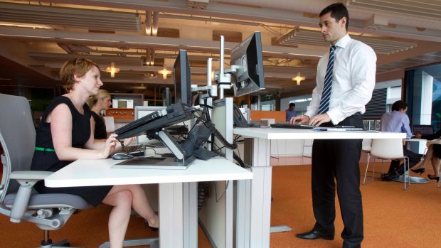 Employees using both sitting and standing desks at the Macquarie Group headquarters in Shelly Street, Sydney.