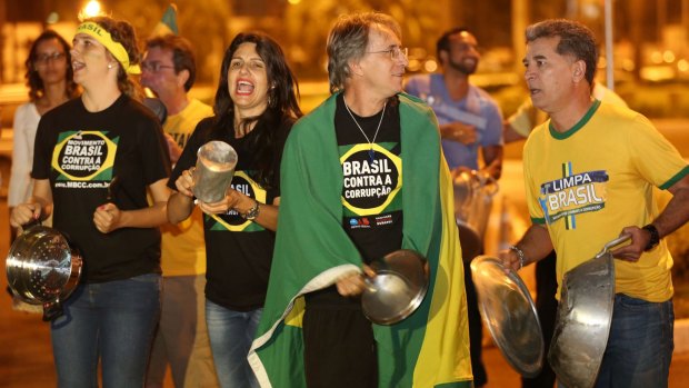 Members of the Brazil's Movement Against Corruption bang on pots and pans in protest against President Dilma Rousseff, during her televised speech.