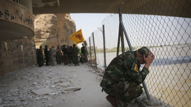 A Badr Brigade militia soldier mourns along the Tigris River in Tikrit, Iraq, earlier this month. Iraqi government forces continue to locate the corpses of up to 1700 soldiers reportedly executed by IS last year.