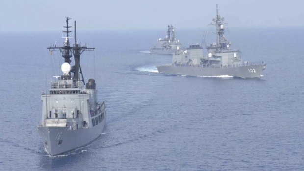 Japanese destroyers sail near a Filipino warship.