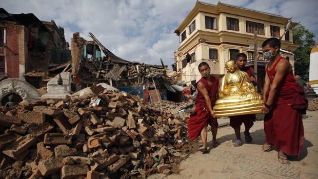 Buddhist monks salvage a statue of a Buddhist deity from a monastery around the famous Swayambhunath stupa after it was damaged in the earthquake in  Kathmandu. 